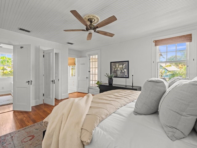 bedroom featuring visible vents, wood finished floors, and multiple windows