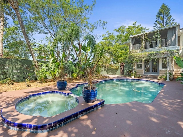 view of pool featuring french doors, a fenced backyard, a sunroom, and a patio area