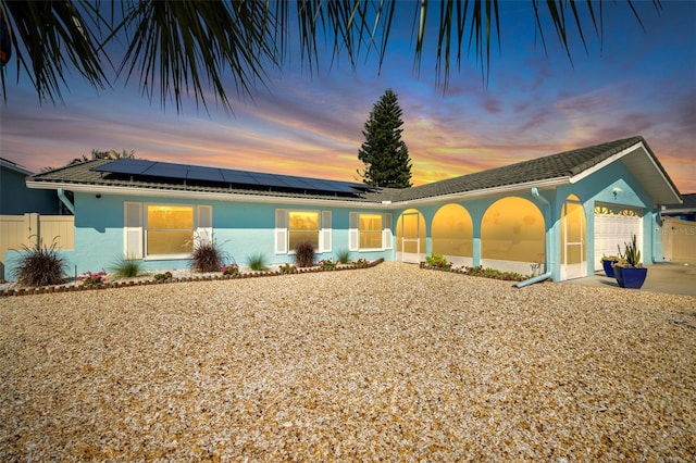 1015 Spindle Palm Way, Apollo Beach, FL 33572 - view of front of home featuring a garage, fence, roof mounted solar panels, and stucco siding