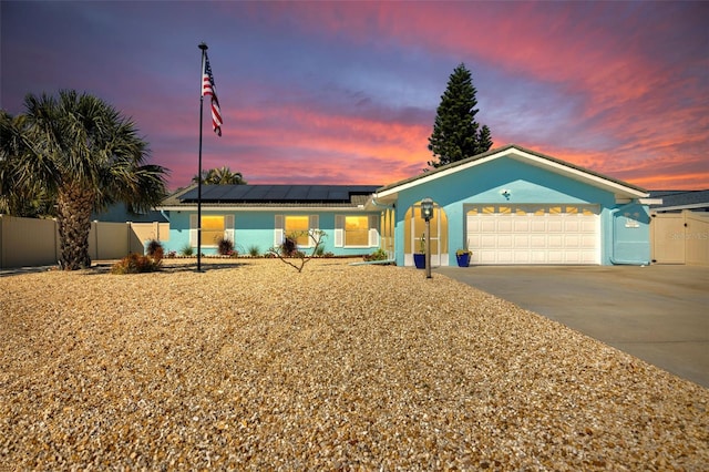 1015 Spindle Palm Way, Apollo Beach, FL 33572 - ranch-style house with fence, an attached garage, stucco siding, concrete driveway, and solar panels