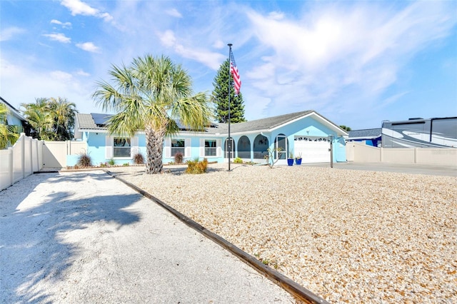 1015 Spindle Palm Way, Apollo Beach, FL 33572 - ranch-style home with fence, solar panels, a gate, and a garage