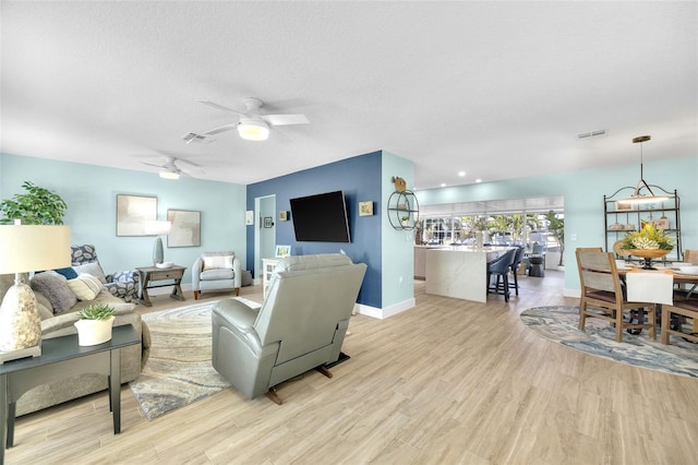1015 Spindle Palm Way, Apollo Beach, FL 33572 - living area featuring visible vents, a ceiling fan, light wood finished floors, and baseboards