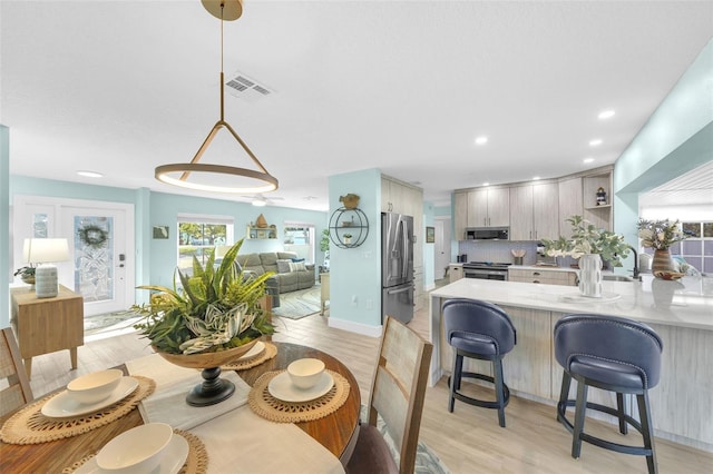 1015 Spindle Palm Way, Apollo Beach, FL 33572 - kitchen featuring light countertops, a peninsula, appliances with stainless steel finishes, and light wood finished floors