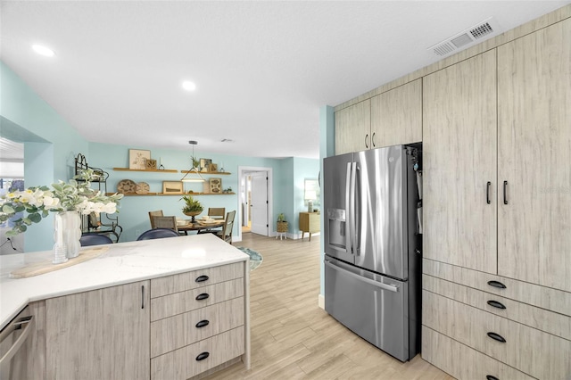 1015 Spindle Palm Way, Apollo Beach, FL 33572 - kitchen with light brown cabinetry, stainless steel refrigerator with ice dispenser, and visible vents