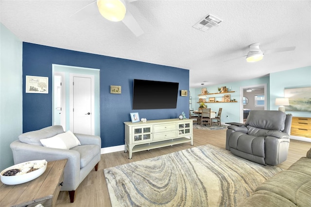 1015 Spindle Palm Way, Apollo Beach, FL 33572 - living area featuring a textured ceiling, ceiling fan, visible vents, and wood finished floors