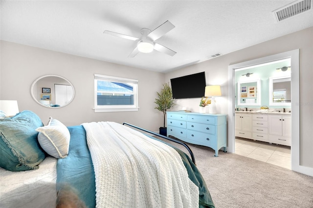 1015 Spindle Palm Way, Apollo Beach, FL 33572 - bedroom featuring visible vents, a ceiling fan, ensuite bath, and light colored carpet