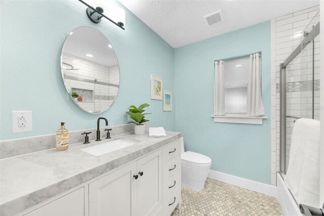 1015 Spindle Palm Way, Apollo Beach, FL 33572 - bathroom featuring visible vents, vanity, toilet, baseboards, and a tile shower