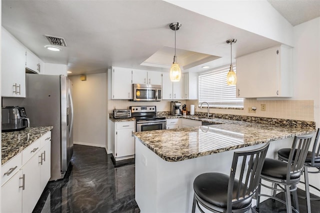 kitchen featuring a peninsula, visible vents, stone counters, and appliances with stainless steel finishes