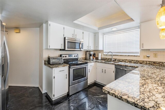 kitchen with a sink, stainless steel appliances, tasteful backsplash, a tray ceiling, and a toaster