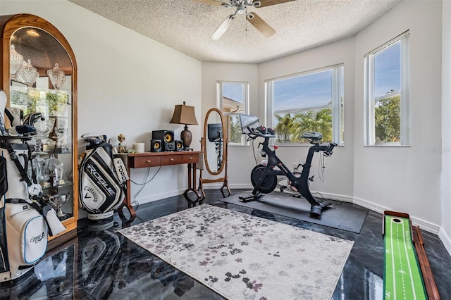 workout room with a textured ceiling, ceiling fan, and baseboards