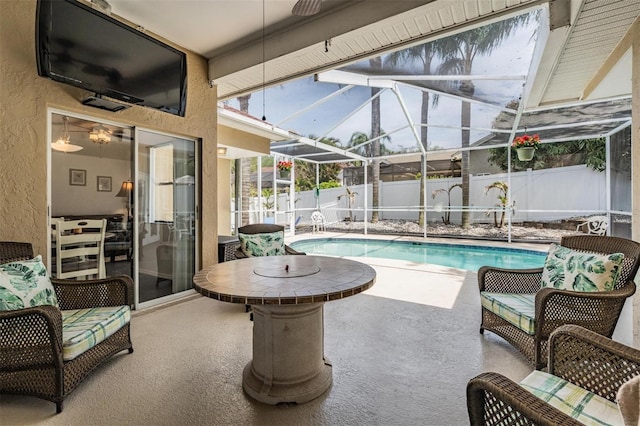 view of swimming pool featuring glass enclosure, a fenced backyard, a fenced in pool, and a patio area