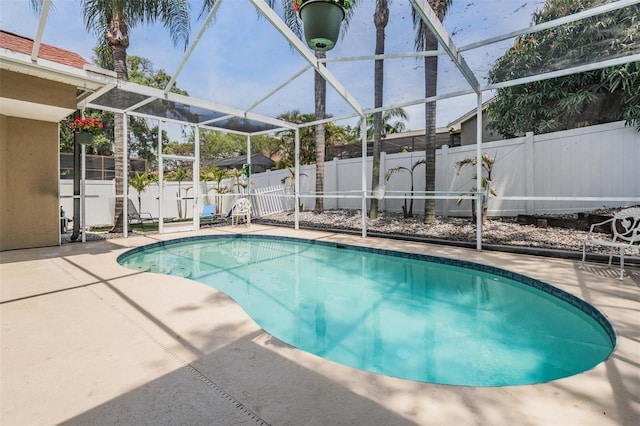 view of pool featuring a fenced in pool, a patio, glass enclosure, and a fenced backyard