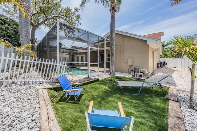 rear view of house with a patio, a fenced backyard, a lawn, stucco siding, and french doors