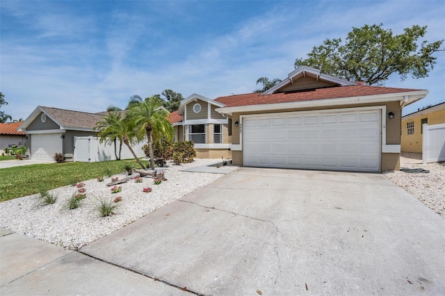 single story home featuring an attached garage, a front yard, driveway, and stucco siding