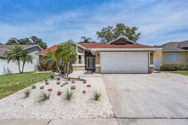 ranch-style house featuring stucco siding, fence, concrete driveway, and an attached garage