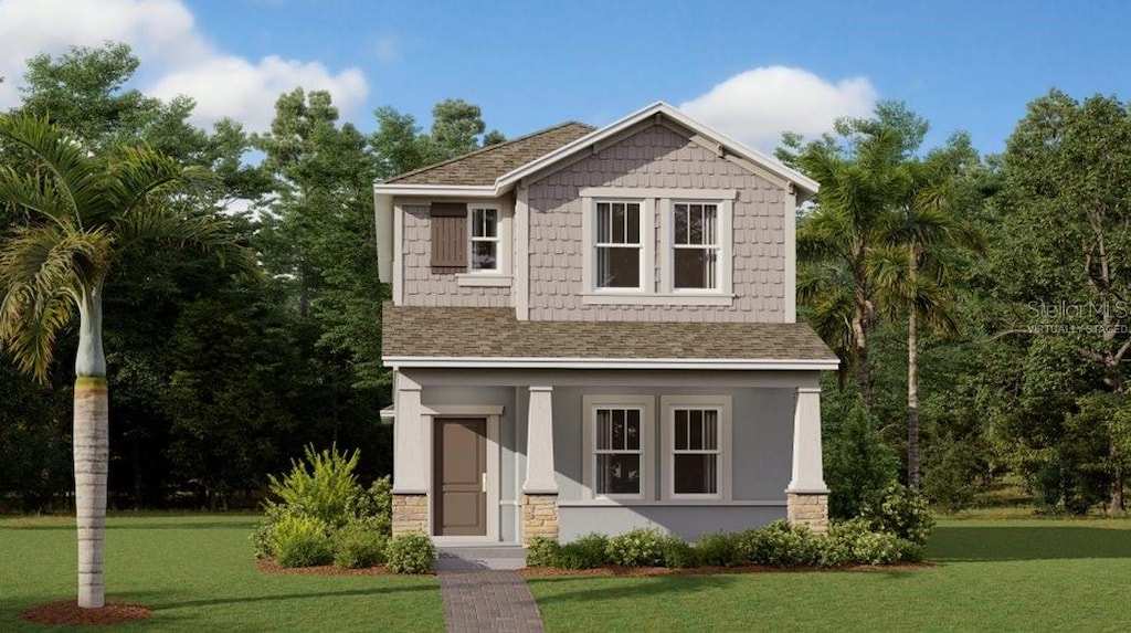 view of front of home with roof with shingles and a front yard