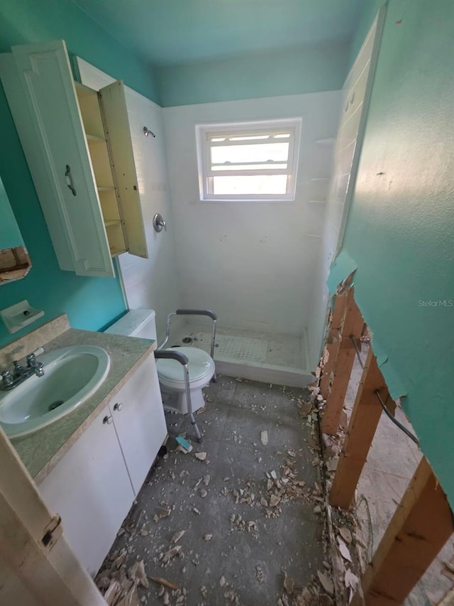 bathroom featuring vanity, toilet, and a stall shower