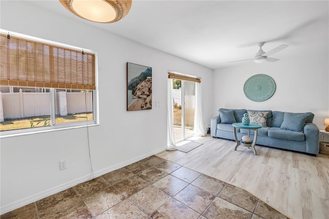 living room with a ceiling fan and baseboards
