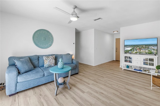 living room with visible vents, a ceiling fan, and light wood-type flooring