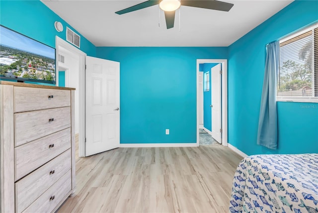 unfurnished bedroom with baseboards, visible vents, wood finished floors, and a ceiling fan