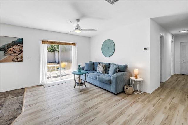 living area with visible vents, ceiling fan, wood finished floors, and baseboards