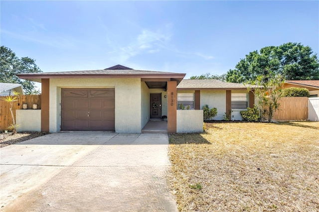 ranch-style home with stucco siding, fence, and an attached garage