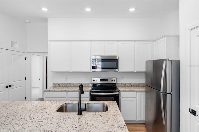 124 Hallam Ct, Spring Hill, FL 34606 - kitchen with a sink, stainless steel appliances, white cabinets, light stone countertops, and visible vents