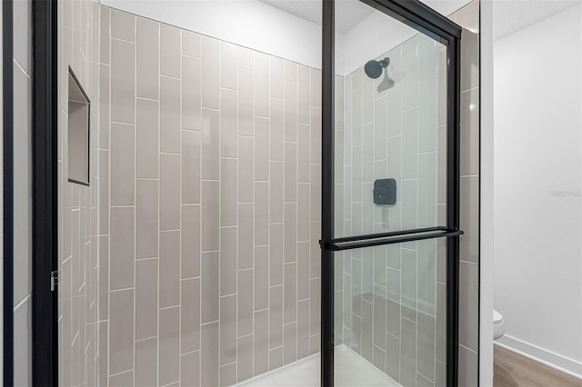 124 Hallam Ct, Spring Hill, FL 34606 - bathroom featuring baseboards, toilet, wood finished floors, and a stall shower