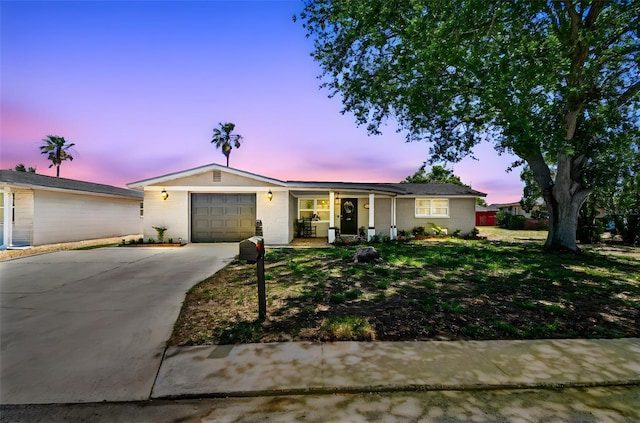 ranch-style home with a garage, covered porch, and driveway