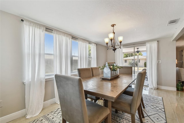dining area featuring baseboards, a notable chandelier, and visible vents