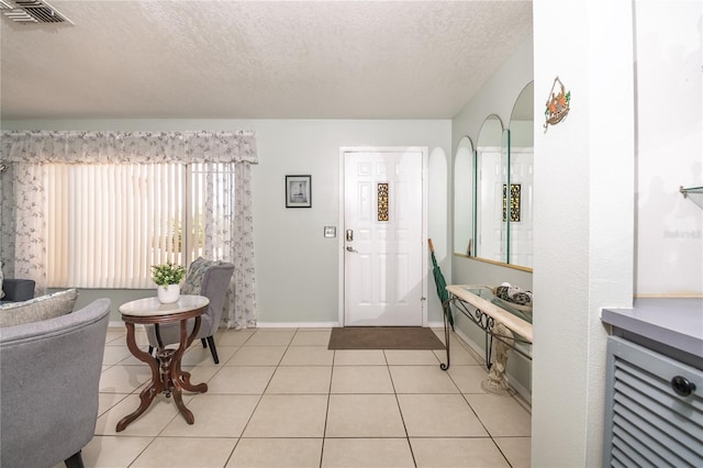 7812 Turnbridge Dr, Port Richey, FL 34668 - foyer entrance featuring a textured ceiling, baseboards, and light tile patterned flooring