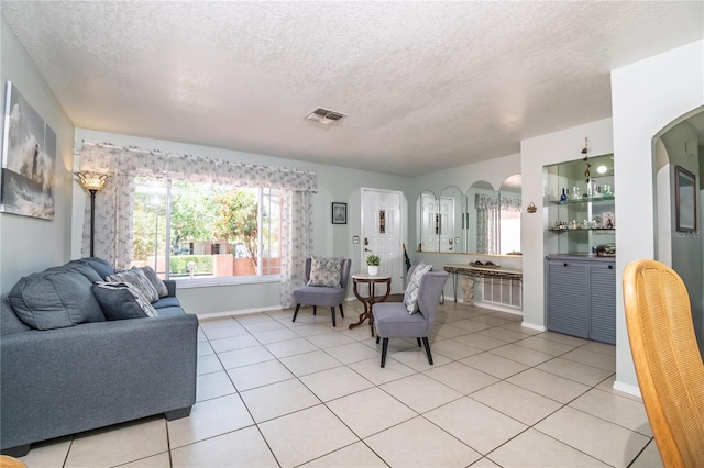 7812 Turnbridge Dr, Port Richey, FL 34668 - living area with a textured ceiling, light tile patterned floors, arched walkways, and baseboards