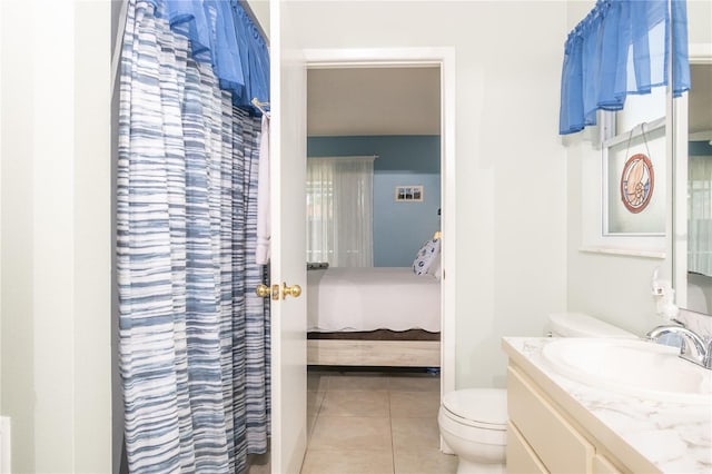 7812 Turnbridge Dr, Port Richey, FL 34668 - ensuite bathroom featuring toilet, tile patterned floors, and vanity