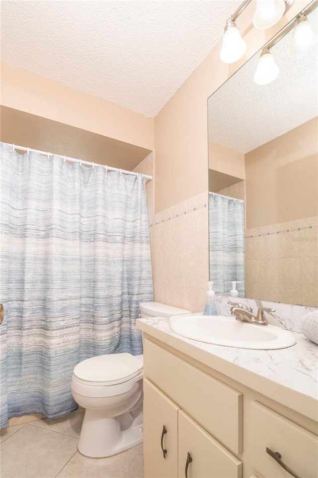 7812 Turnbridge Dr, Port Richey, FL 34668 - bathroom featuring a textured ceiling, tile walls, vanity, toilet, and tile patterned floors