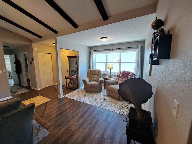 living room featuring beamed ceiling, wood finished floors, and baseboards