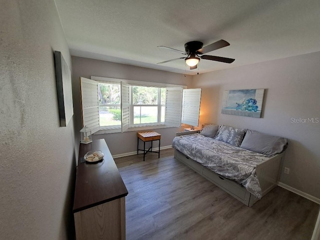 bedroom featuring a ceiling fan, wood finished floors, and baseboards