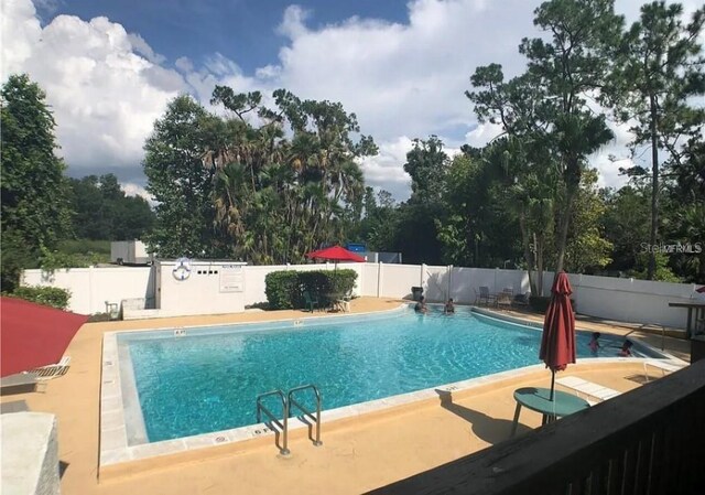 pool with fence and a patio area
