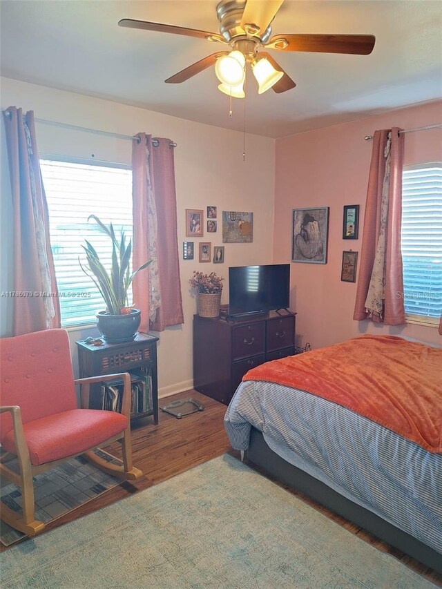 bedroom featuring wood finished floors, a ceiling fan, and baseboards