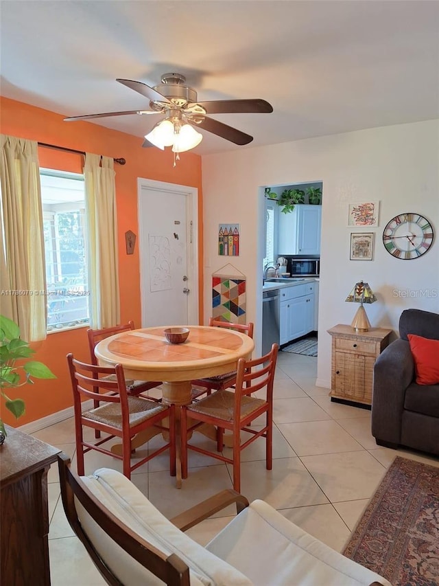 dining area with light tile patterned flooring, a ceiling fan, and baseboards