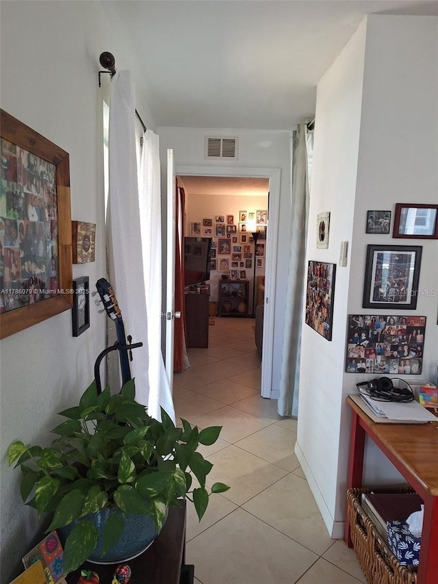 hallway with visible vents and light tile patterned floors