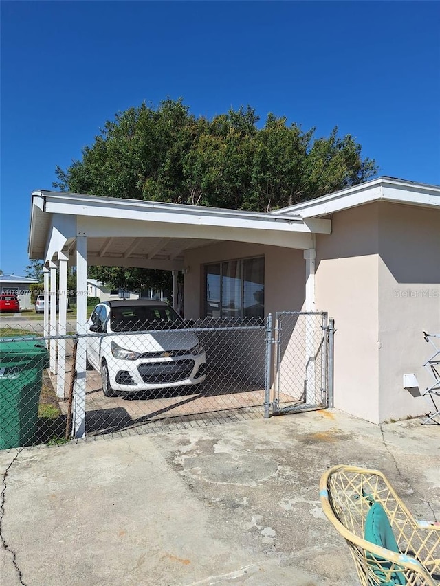 exterior space with fence, a gate, and an attached carport
