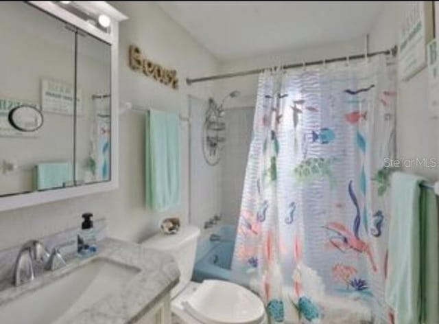 full bath with shower / bath combo with shower curtain, toilet, and vanity