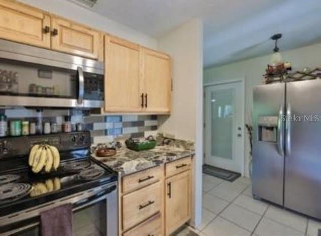 kitchen with backsplash, light brown cabinetry, stainless steel appliances, and light tile patterned flooring