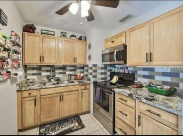 kitchen featuring light brown cabinetry, tasteful backsplash, visible vents, a ceiling fan, and appliances with stainless steel finishes