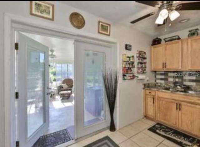kitchen featuring decorative backsplash, a ceiling fan, light brown cabinetry, and light tile patterned flooring