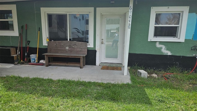6904 11th Ave E, Palmetto, FL 34221 - doorway to property featuring a yard and stucco siding