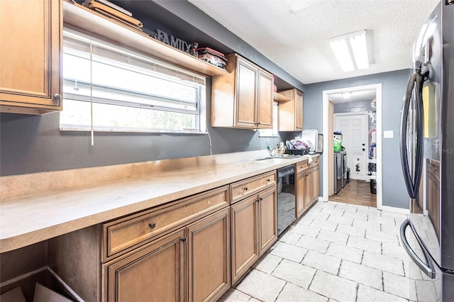 2002 SE Rhode Island St, Arcadia, FL 34266 - kitchen featuring washer and clothes dryer, open shelves, light countertops, dishwasher, and freestanding refrigerator