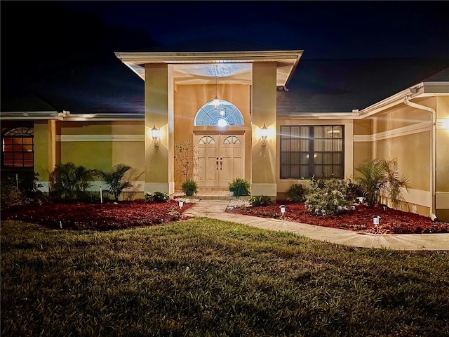 exterior entry at twilight with a lawn