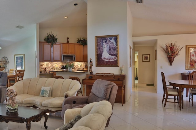 living area featuring light tile patterned flooring, recessed lighting, lofted ceiling, and visible vents