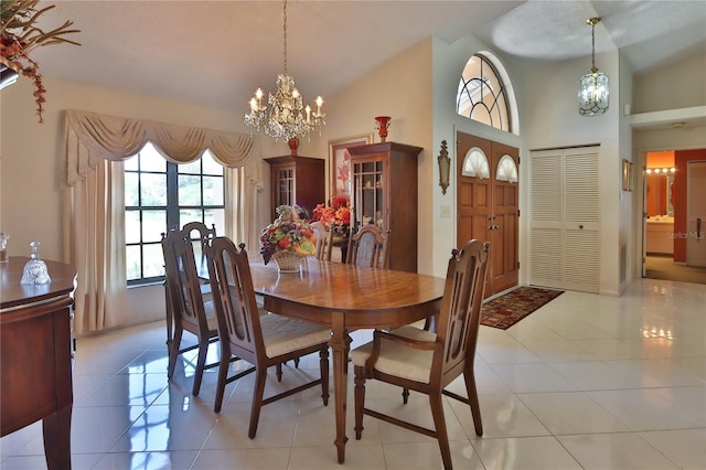 dining area featuring an inviting chandelier, light tile patterned floors, and high vaulted ceiling